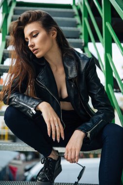 deri ceketli genç kız sigara içiyor, rock tarzı, arsız ve sevimli kız sokak poz tarzı, rock punk yaşam tarzı