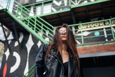 deri ceketli genç kız sigara içiyor, rock tarzı, arsız ve sevimli kız sokak poz tarzı, rock punk yaşam tarzı