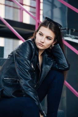 deri ceketli genç kız sigara içiyor, rock tarzı, arsız ve sevimli kız sokak poz tarzı, rock punk yaşam tarzı
