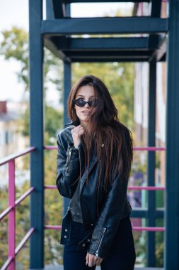 deri ceketli genç kız sigara içiyor, rock tarzı, arsız ve sevimli kız sokak poz tarzı, rock punk yaşam tarzı
