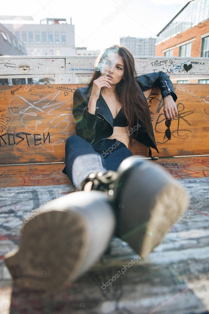 young girl in a leather jacket smokes cigarettes, rock style, cheeky and cute girl street posing style, rock punk lifestyle