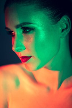 Güzel bir genç kızın yüzüne çarpıcı bir makyaj, güzellik makyajı, yüzünde yağ ve kırmızı renkli parlaklıklar öncelikli olacak.