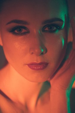 Güzel bir genç kızın yüzüne çarpıcı bir makyaj, güzellik makyajı, yüzünde yağ ve kırmızı renkli parlaklıklar öncelikli olacak.