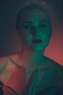 Güzel bir genç kızın yüzüne çarpıcı bir makyaj, güzellik makyajı, yüzünde yağ ve kırmızı renkli parlaklıklar öncelikli olacak.