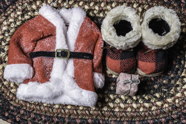 圣诞前夕 圣诞老人的外套和靴子平铺在织成的地毯上 — 图库照片