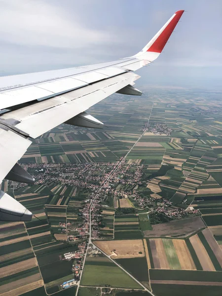 Aerial view from aircraft on a fields, settlement and road