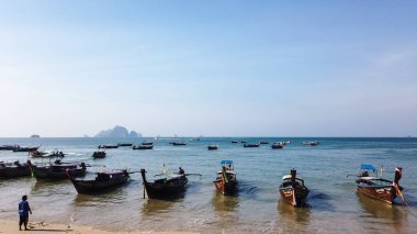 Kumlu bir plaj ve kıyı Ao Nang, Krabi, Tayland - 21 Ocak 2019:Thai uzun kuyruk tekne palamarla