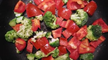 Sebze brokoli ve kırmızı tatlı kırmızı biber biber bir tencerede kızartılır. Görünüm doğrudan yukarıdaki