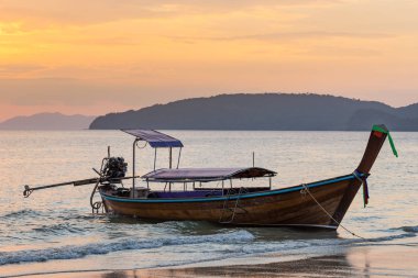 Bir gün batımında sahilde Tay geleneksel uzun kuyruk tekne demirleyen