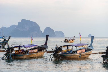Birkaç gün batımında kıyıya yakın deniz suyundaki Tay geleneksel uzun kuyruk tekne palamarla
