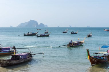 Adalara turistler ile mavi deniz suyunda kıyıdan Tayland uzun kuyruklu tekne yelken
