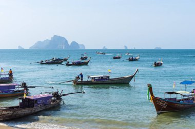 Birçok Tay uzun kuyruk otantik tekneler mavi deniz suyunda kıyıya yakın yüzer ve turistler için bekleyin