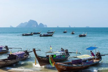 Birçok Tay yerel uzun kuyruk otantik tekneler masmavi deniz suyunda kıyıya yakın yüzer ve yolcular için bekleyin