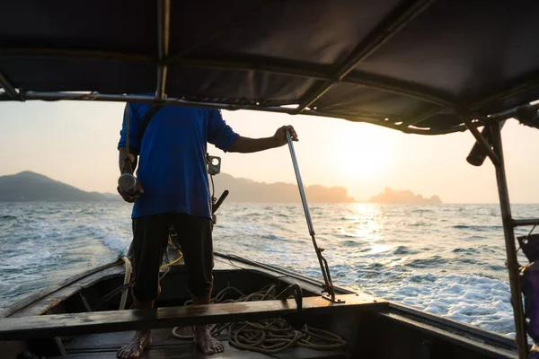 A local resident is sailing on a Thai long-tail boat in the sea