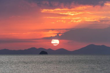 Denizde pitoresk gün batımı. Güneş büyük kırmızı daire ufuk arkasında setleri