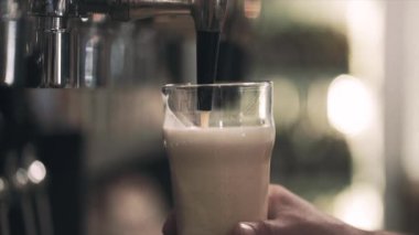 El bir cam tutarak ve musluk zanaat pub azot bira dökün. Ön bakış. Bokeh arka plan bulanık. Yavaş hareket