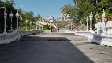 Krabi Town, Tayland - 11 Ocak 2019: Beyaz tapınak Wat Kaew Korawaram'ın gündüz görünümü. Kamera çit girişinden topraklarında merdivenileri ileri ye doğru hareket eder