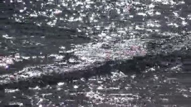 Güneşin sudaki parlaklığı, dalgalar Odessa, Ukrayna 'da deniz kıyısında yuvarlanıyor.