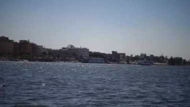 LUXOR, EGYPT - 5 Nisan 2019: Luxor 'daki Nil Nehri' ndeki turistik tekne, Mısır 'ın Nil Nehri' ndeki bir tekneden kıyıya bakıyor