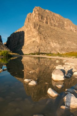 Sığ bir nehirde beyaz tuzla kaplı taşlar suya yansıyor. Santa Elena Kanyonu ve Rio Grande. Santa Elena Kanyonu 'nun Big Bend Ulusal Parkı manzarası. 
