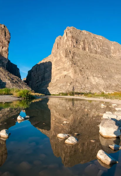 Sığ bir nehirde beyaz tuzla kaplı taşlar suya yansıyor. Santa Elena Kanyonu ve Rio Grande. Santa Elena Kanyonu 'nun Big Bend Ulusal Parkı manzarası. 