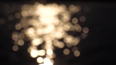 Suyun üzerinde güneşin bulanık parlaklığı.