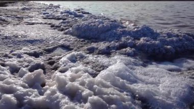 Kuyalnik haliçleri, Karadeniz. Beyaz köpük ve tuz kristalleri tuz gölünün kıyısındaki taşları kaplıyor.