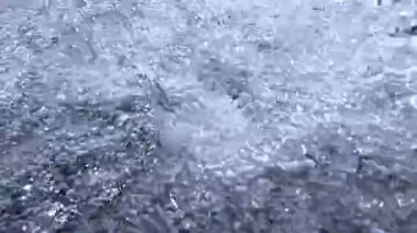 Su kabarcıkları, su damlaları güneşte parlıyor.