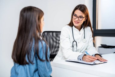 Doktor psikoterapist, terapist ya da beyaz önlüklü çocuk doktoru klinikteki resepsiyonda genç bir kızı dinler. Gençlik sorunları, terapi seansı, ergen tıp çocuk doktoru konsepti.
