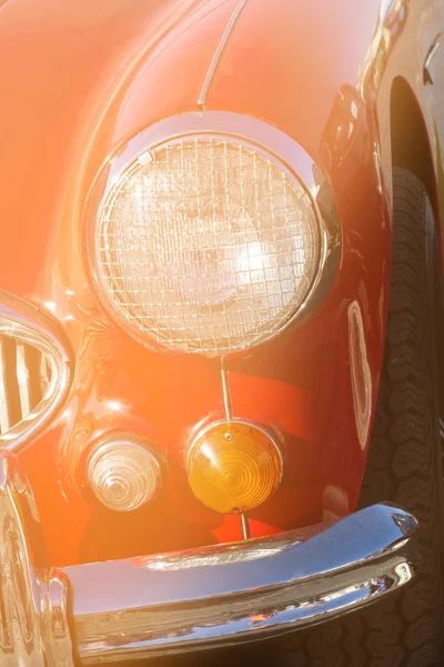 A fragment of a retro car in close-up. Headlights and rider.