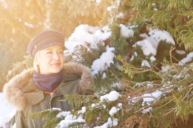 Siyah bere kışın karda bir Noel ağacı yakınındaki sokakta bir kız portresi