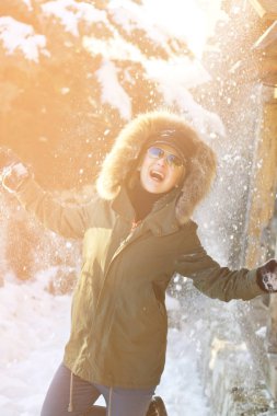 Koyu yeşil sigara içen kızın kafasından kar düşüyor