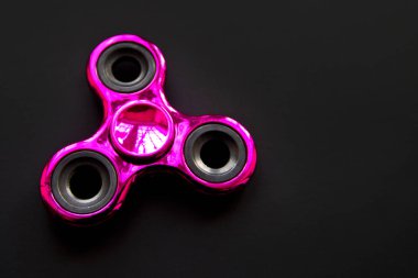Parmak metal spinner, Anksiyete Rölyef oyuncağın üstüne siyah arka plan, boşaltmak kıpır. Kavram giderici stres