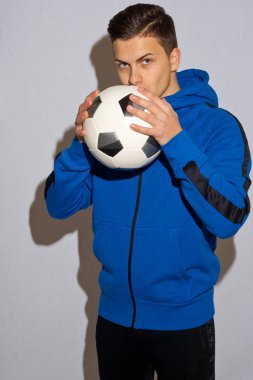 Beyaz arka plan önünde topu ile genç futbolcu