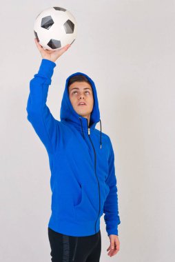 Beyaz arka plan önünde topu ile genç futbolcu