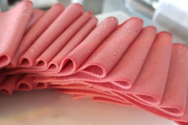 pişmiş haşlanmış jambon sosis veya haddelenmiş bologna dilimleri üzerinde beyaz arka plan kesme izole