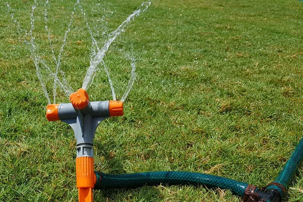 automatic sprinkler system watering the lawn on a background of green grass, close-up