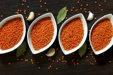 Üstten görünüm karanlık bir ahşap zemin üzerine kırmızı mercimek bir dizi.