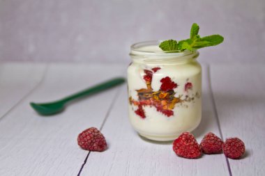Tenekeleri Frambuaz ve nane ile yoğurt yakın çekim yaprak.