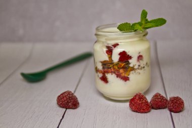 Tenekeleri Frambuaz ve nane ile yoğurt yakın çekim yaprak.