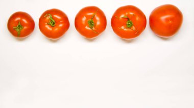 Domateslerin hepsi beyaz arka planda üst üste. Üstte görüntü