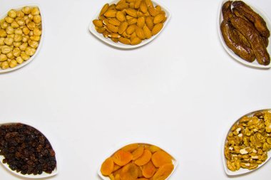 Kopya alanı ile beyaz bir arka plan üst görünümünde kase fındık ve kurutulmuş meyve çeşitliliği