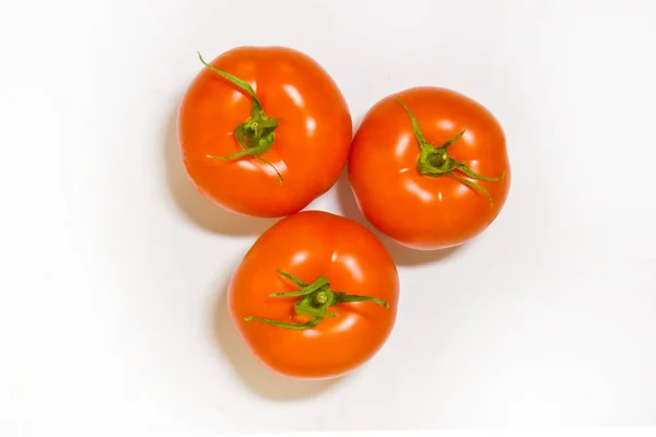 Свежие помидоры на белом фоне с естественным оттенком. Вид сверху — стоковое фото