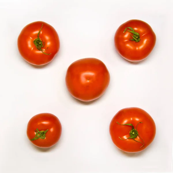 Целые помидоры аккуратно сложены на белом фоне. Вид сверху — стоковое фото