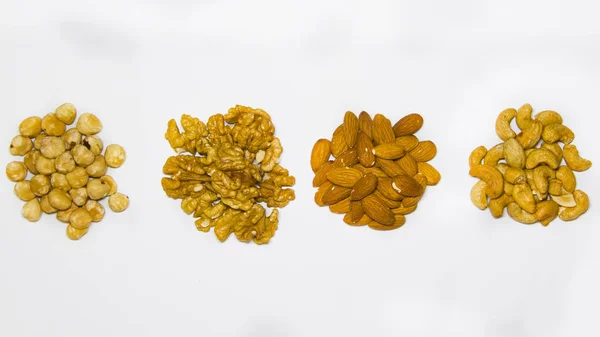 Combinazione di mandorle con nocciole di anacardi e noci confezionato su uno sfondo bianco con una vista dall'alto — Foto Stock