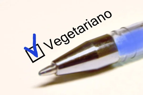 Questionnaire. Bjue pen and the inscription VEGETARIAN with cross on the white paper