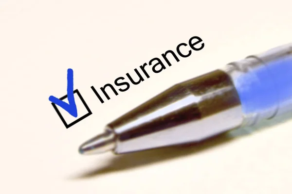 Questionnaire. Blue pen and the inscription INSURANCE with cross on the white paper