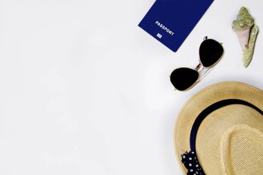 Deniz kabukları, şapka, güneş gözlüğü, kum ile ışık arka planda pasaport, üst görünüm