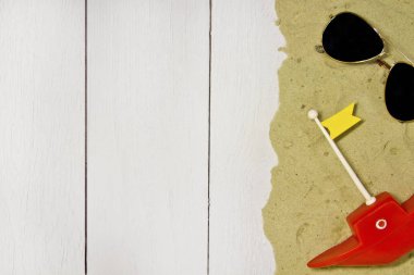 Deniz güneş gözlüğü, kum, hafif bir ahşap zemin üzerine oyuncak tekne görünümü top