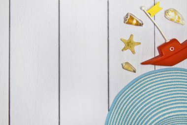 Seyahat - oyuncak tekne, şapka, çeşitli egzotik kabukları ve diğer Deniz hazineler üstten kum görünüm hafif bir ahşap zemin üzerine kavramı